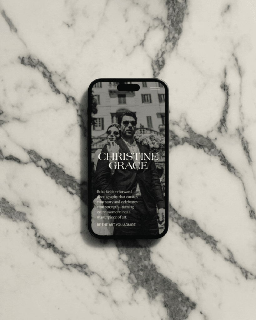 Marble flatlay featuring an iPhone website design mockup with a black-and-white couple portrait and the Christine Grace logo.
