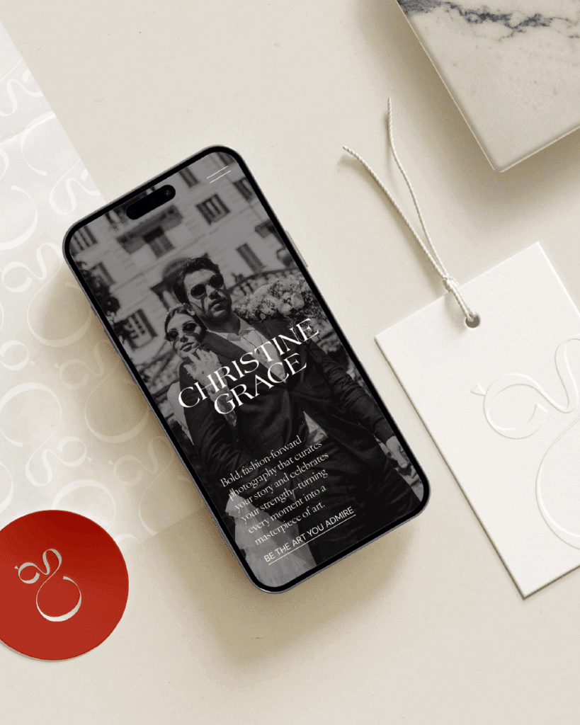 iPhone mockup with a bold black-and-white couple portrait on-screen, styled next to neutral paper textures and tags.