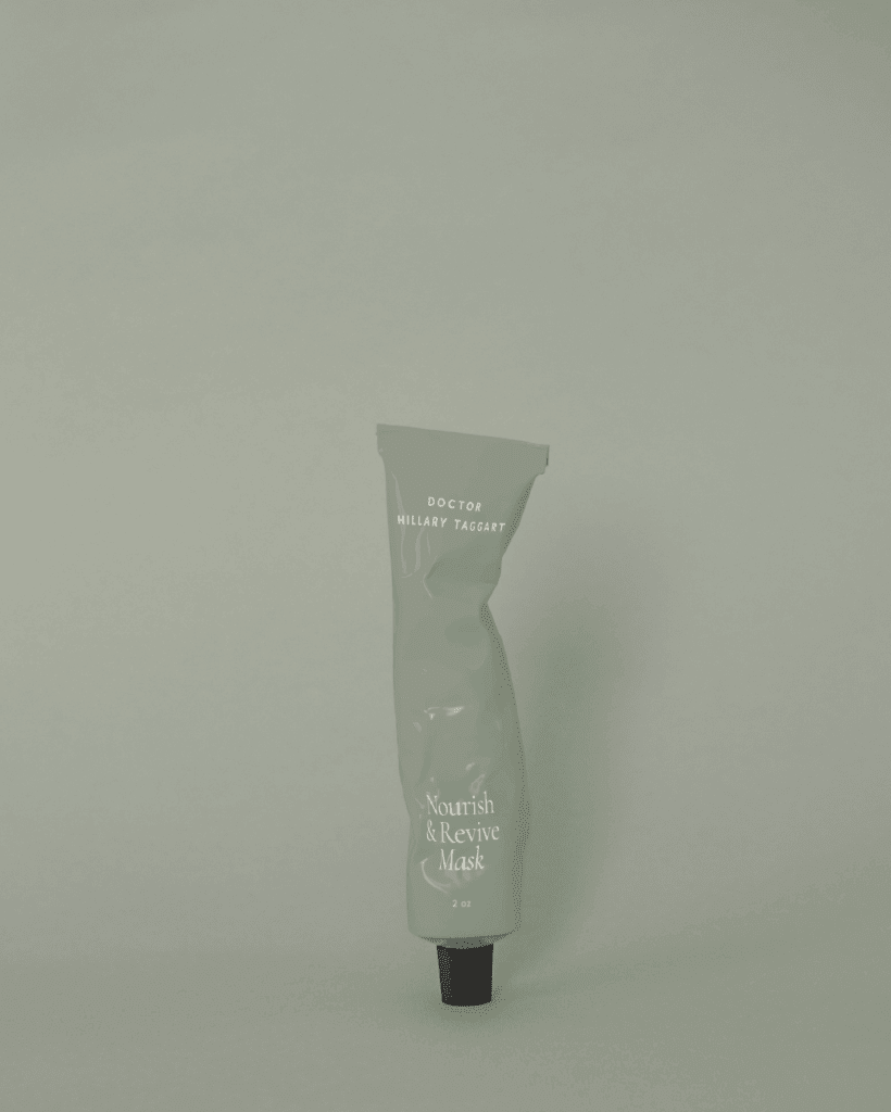 Product mockup of the Nourish & Revive Mask in a sage green tube with minimalist white lettering and brand logo.