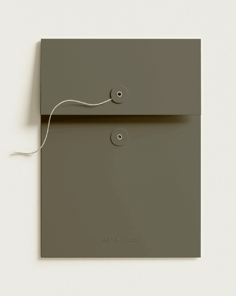 Custom olive green folder with string closure and embossed Baya Voce branding, part of the high-touch client experience.