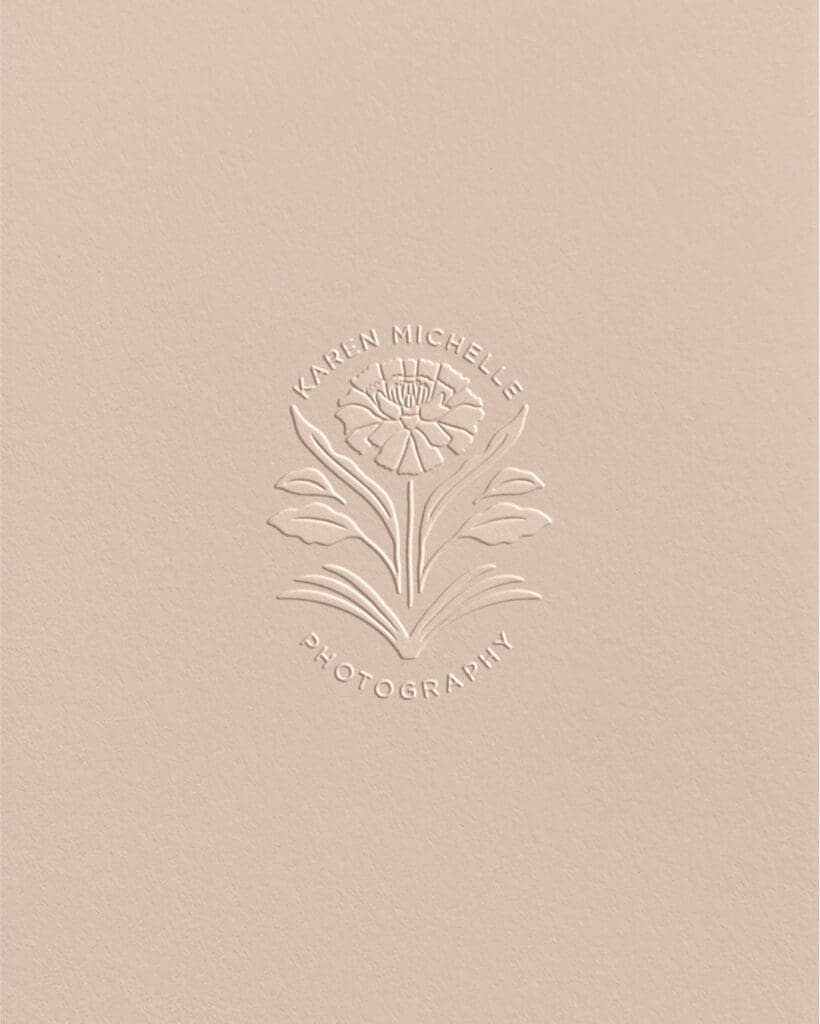 Close-up of embossed Karen Michelle Photography emblem—marigold symbol representing memory and heritage.