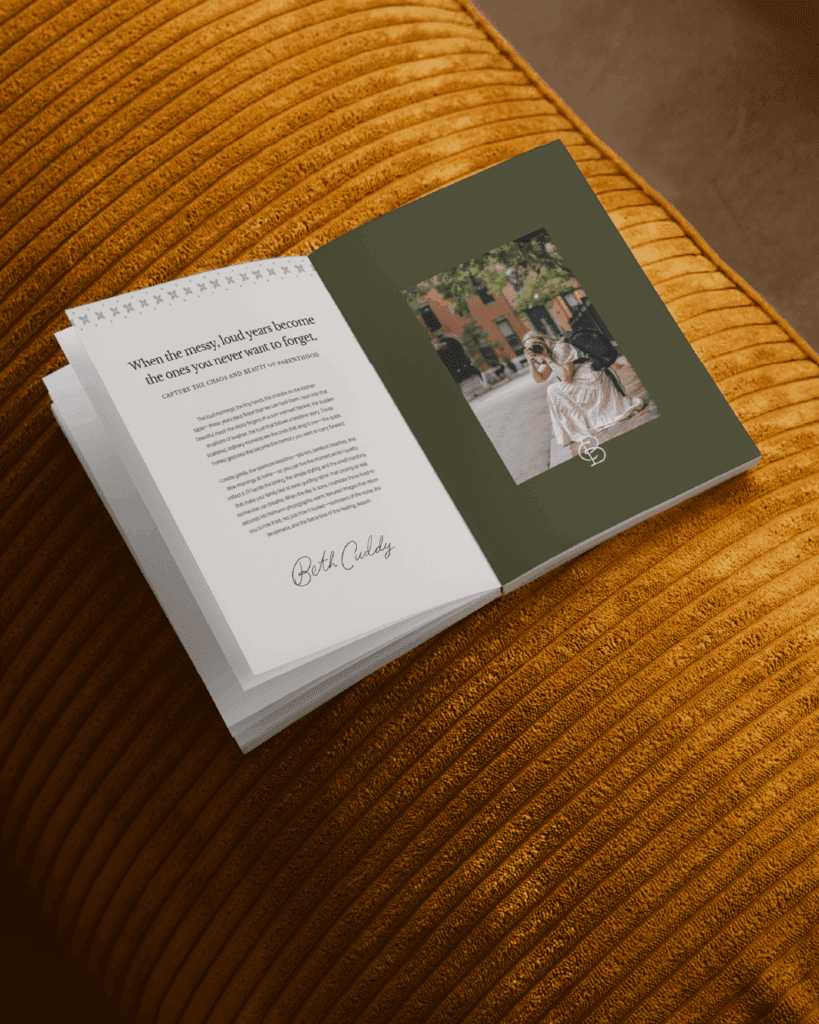 Open brand booklet on rust-colored cushion, showing Beth Cuddy’s brand messaging and a photo of Beth with her camera.